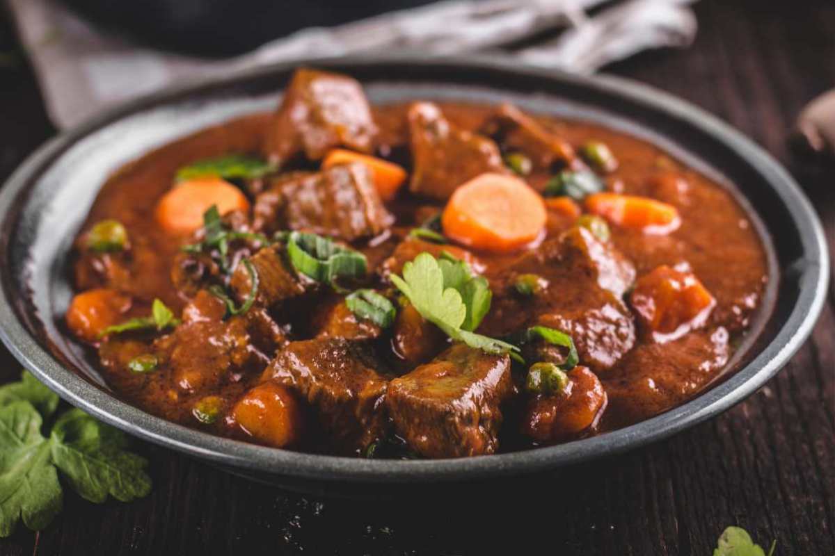 piatto con carne cotta in umido, carote e prezzemolo