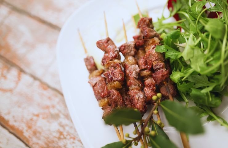 arrosticini e insalata su un piatto