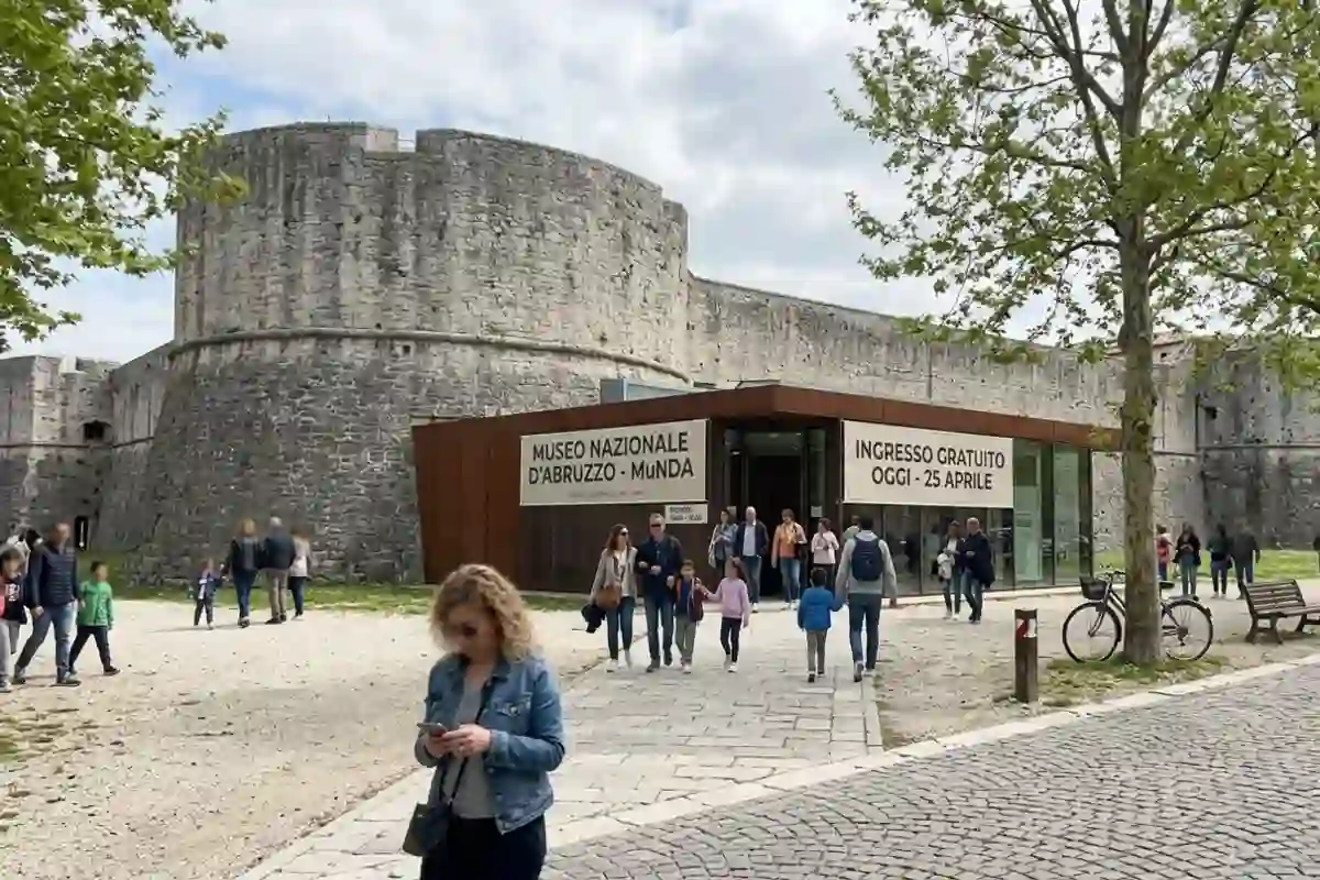 Ingresso del Museo Nazionale d'Abruzzo MuNDA a L'Aquila con visitatori e cartello ingresso gratuito per il 25 aprile, esterno del Forte Spagnolo.