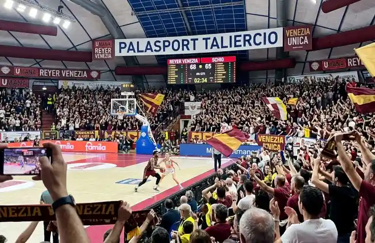 Tifosi Reyer Venezia al Palasport Taliercio durante la finale scudetto basket contro Schio, atmosfera live con bandiere e spalti gremiti.