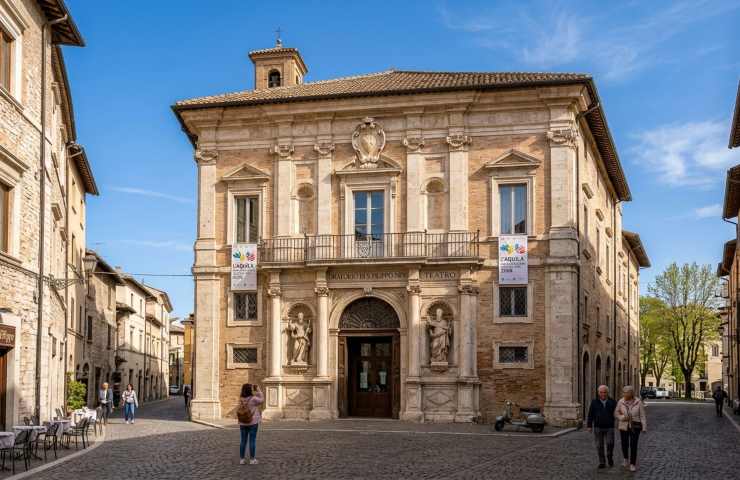 Facciata esterna Teatro San Filippo Neri L'Aquila, architettura barocca nel centro storico con stendardi Capitale della Cultura 2026.