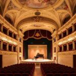 Interno restaurato Teatro San Filippo L'Aquila barocco, platea e palco con pianoforte per Capitale Italiana della Cultura 2026.