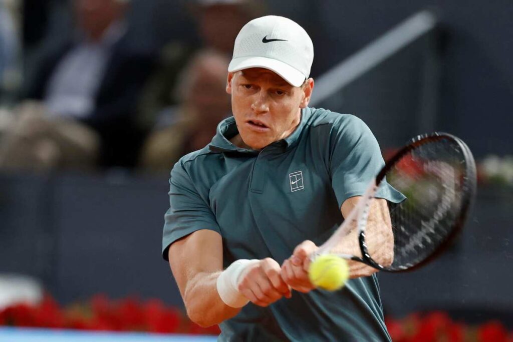 Jannik Sinner colpisce la pallina con la racchetta esibendosi in un rovescio a due mani.