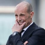 Massimiliano Allegri si tiene il mento mentre osserva una partita della sua squadra da bordo campo.