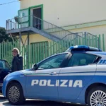 Auto della polizia parcheggiata in strada davanti ad un edificio di giorno.
