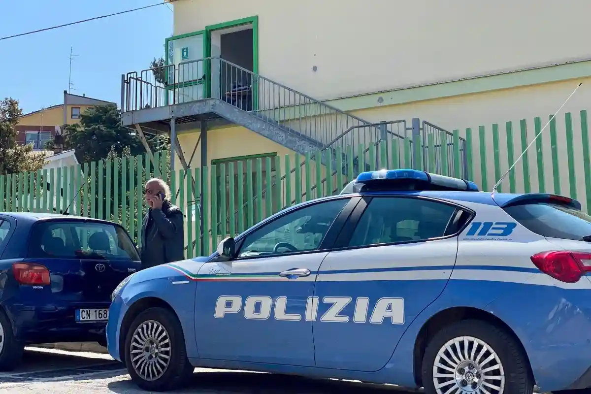 Auto della polizia parcheggiata in strada davanti ad un edificio di giorno.