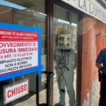 Carabiniere davanti all'ingresso di un ristorante chiuso per inadempienze sulla sicurezza.