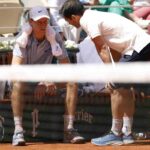 Jannik Sinner seduto a bordo campo colpito da un malessere.