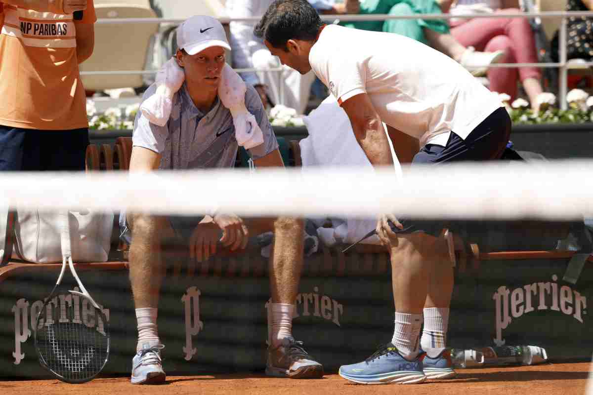 Jannik Sinner seduto a bordo campo colpito da un malessere.