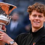 Jannik Sinner sorridente mentre regge la coppa di vincitore degli Internazionali di Roma di tennis.