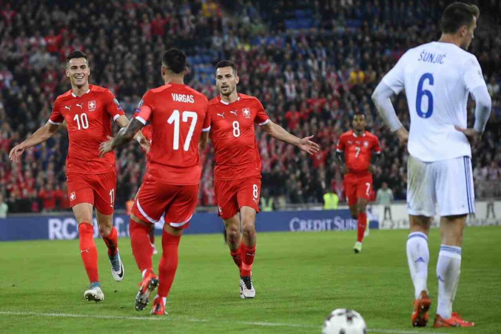 Svizzera-Bosnia ai Mondiali 2026, esultanza dei giocatori svizzeri durante una partita decisiva del Girone B in uno stadio gremito.